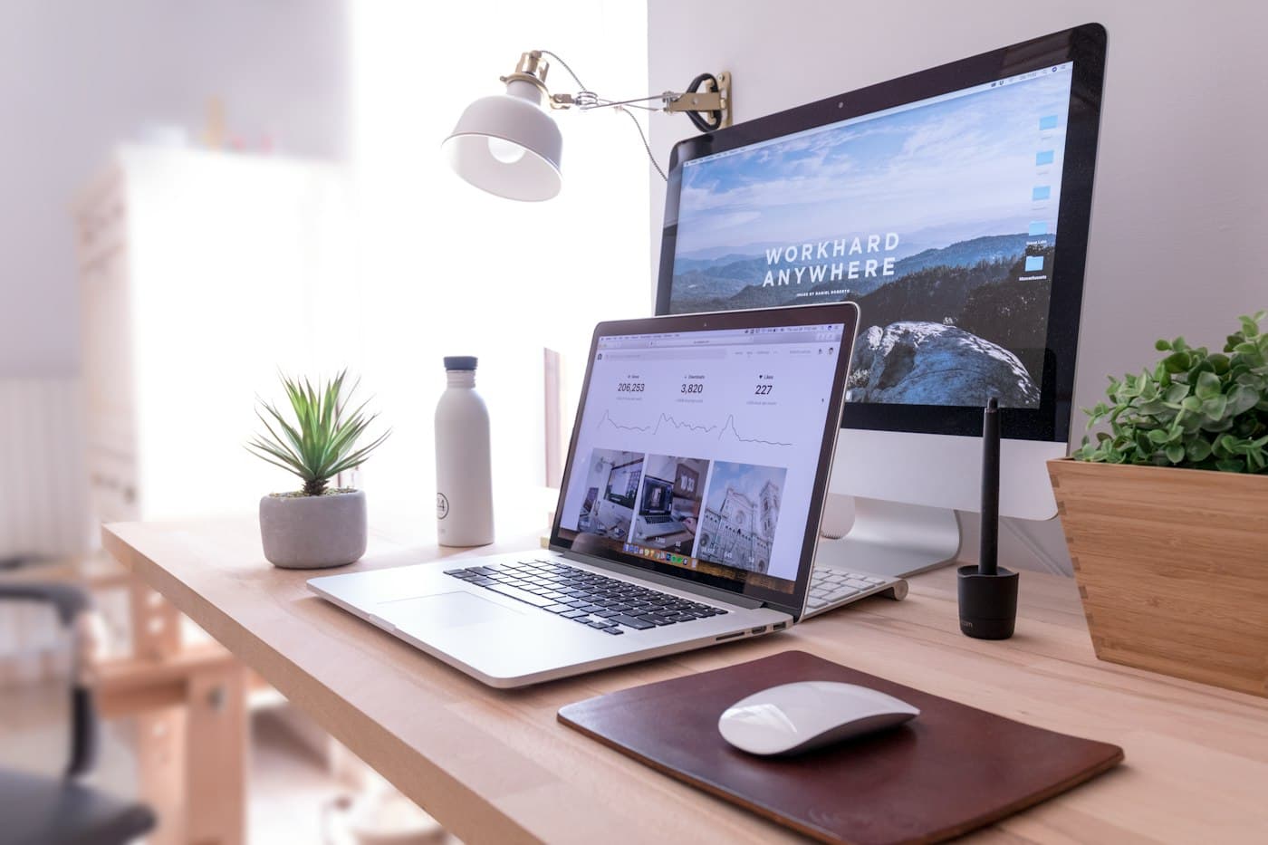A laptop and monitor showing a finished business website on a tidy desk